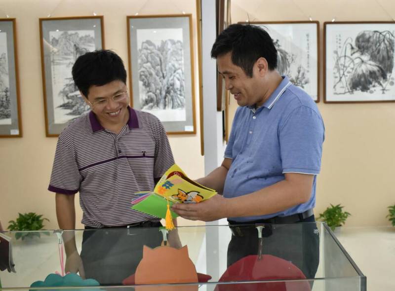 2018年9月14日校长韩峻峰（左）参观永利总站ylzz第一届师生书画作品展。