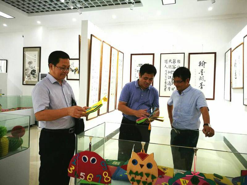 2018年9月10日学校党委陈锦山副书记（右）参观永利总站ylzz第一届师生书画作品展。