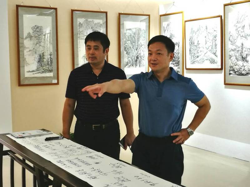 2018年9月11日学校党委陈湘如副书记（右）参观永利总站ylzz第一届师生书画作品展。